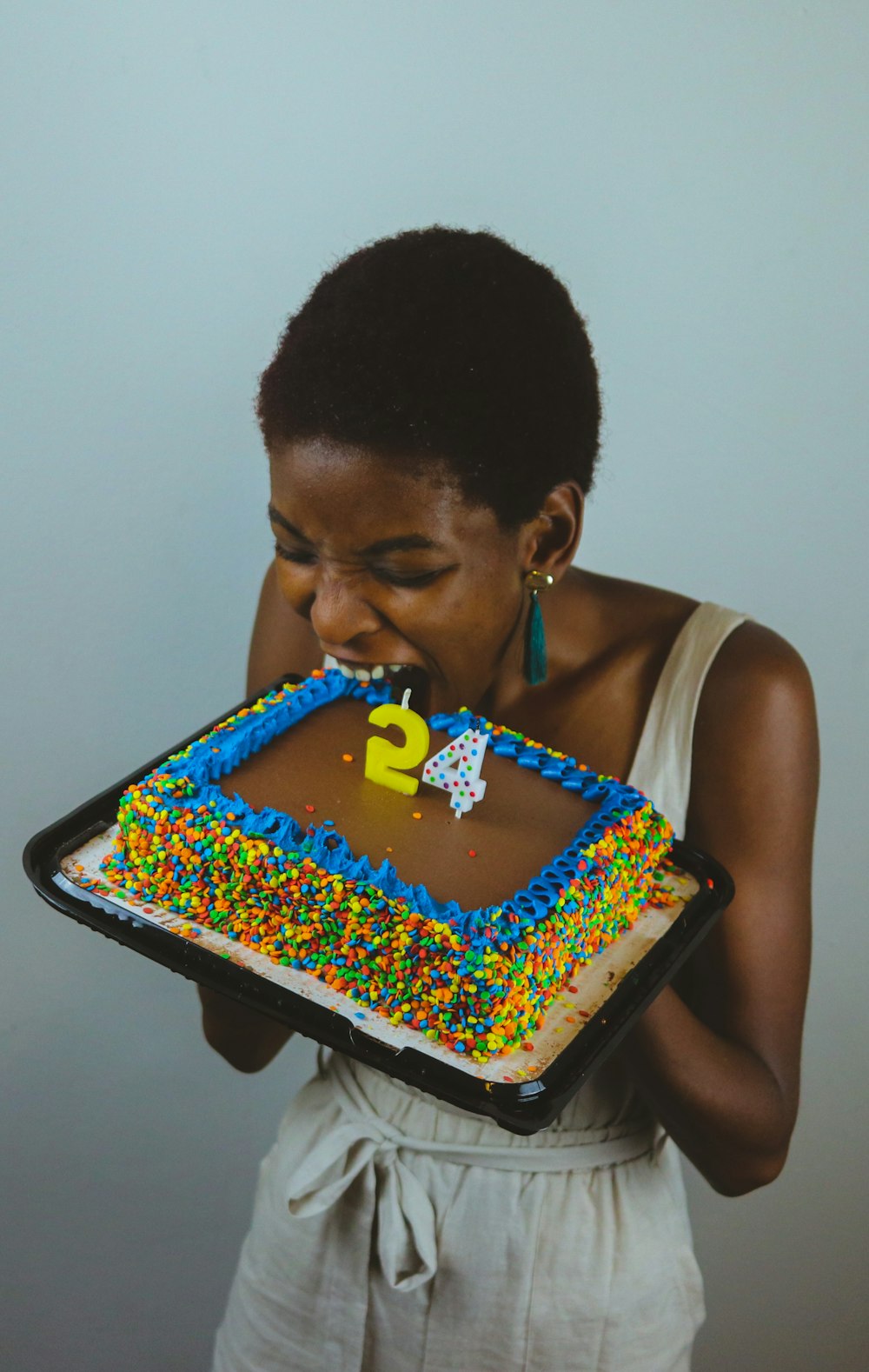 man in white tank top holding cake