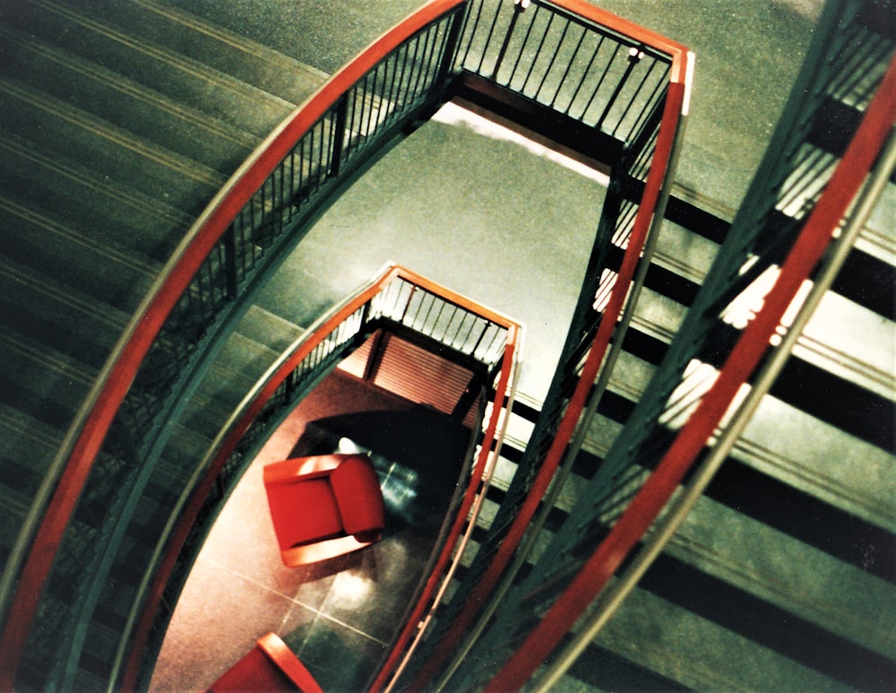 Escada em espiral de madeira marrom com almofada vermelha