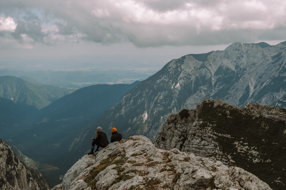 person sitting on rock mountain during daytime