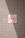 A no smoking sign is displayed on a wall with a light gray tile pattern. The sign features a cigarette symbol crossed out with a red circle and diagonal line. Sunlight casts a shadow across part of the tiles and the sign, creating contrasting areas of light and shadow.