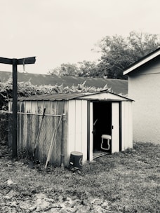 A spacious tool shed with double doors, made from wood-textured metal sheets.