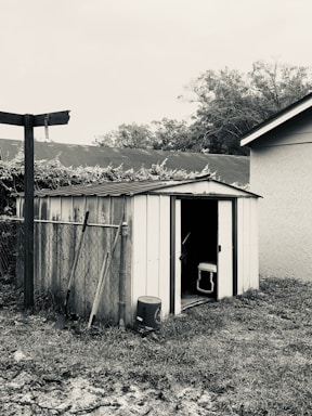 A spacious tool shed with double doors, made from wood-textured metal sheets.