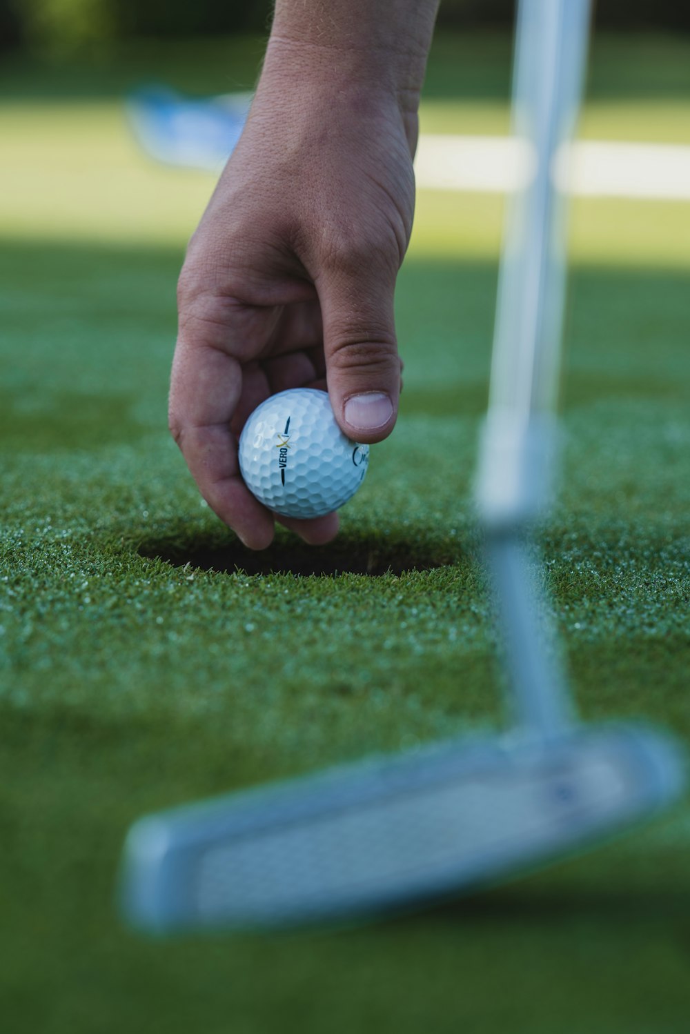 balle de golf blanche sur un terrain en herbe verte pendant la journée