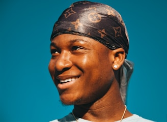 Smiling woman wearing Rosybling earrings, sunlight highlighting their shine.