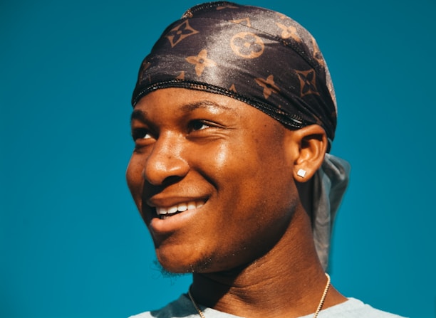 Smiling woman wearing Rosybling earrings, sunlight highlighting their shine.