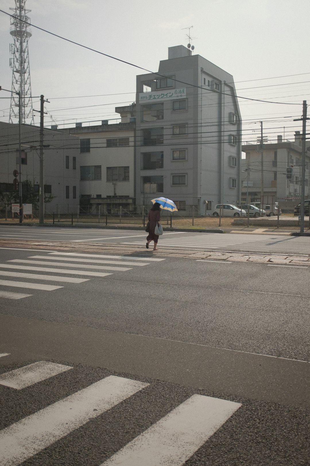 person in white jacket walking on sidewalk during daytime
