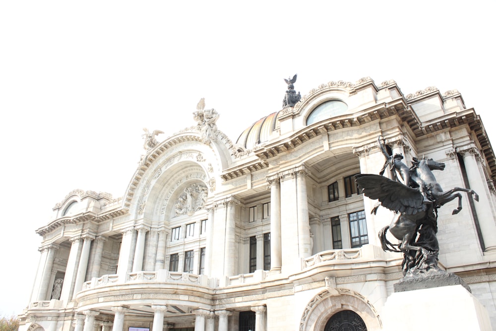 black horse statue in front of white concrete building