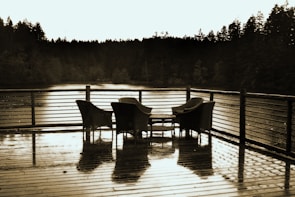 Spacious deck with rocking chairs overlooking a tranquil wooded pond.