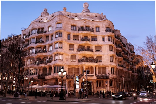 people walking near brown concrete building during daytime in Casa Mila Spain