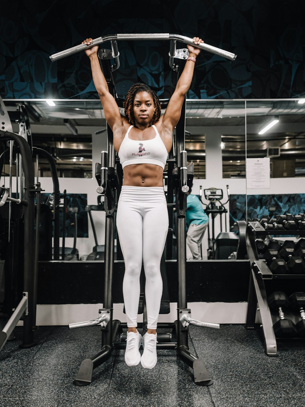 woman in white tank top and white pants doing exercise