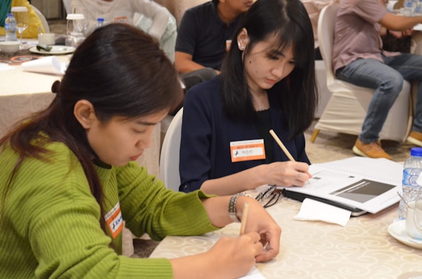 Close-up of hands writing notes during a practical workshop