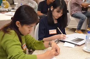 Close-up of hands writing notes during an educational workshop.