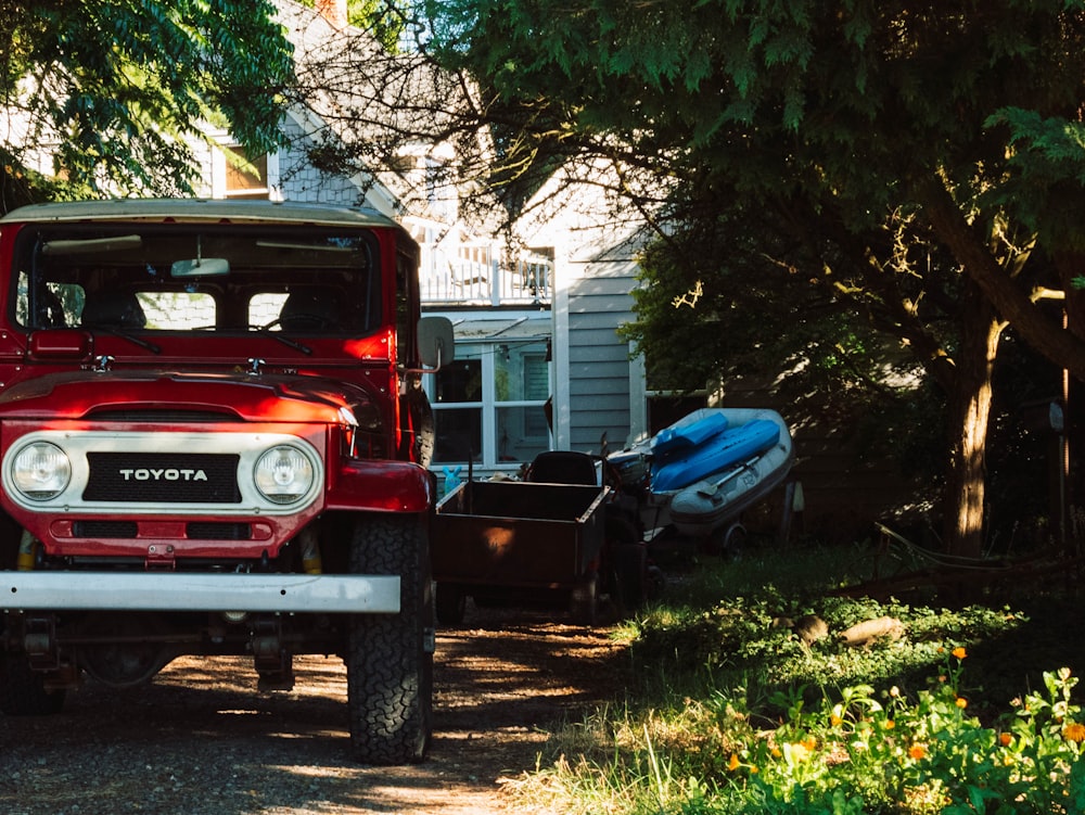 red chevrolet crew cab pickup truck parked beside blue car