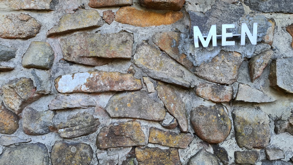 white and black letter m print on gray concrete wall