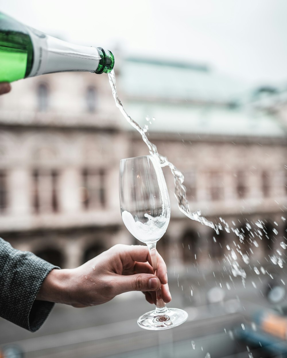 person pouring water on clear wine glass