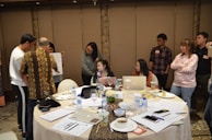 Team collaborating over digital devices in a bright meeting room.