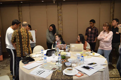 Team collaborating over business strategy documents in a bright meeting room.