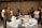 A group of professionals collaborating around a conference table with laptops and documents.