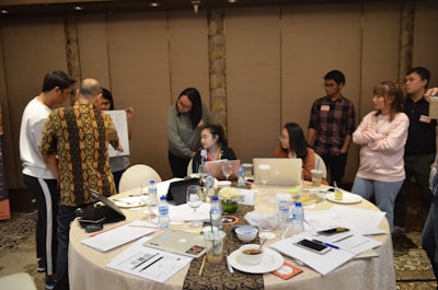 Team members collaborating over documents in a bright conference room.