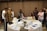A diverse group of professionals collaborating around a table with laptops and documents.