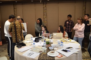 A team collaborating around a table with digital devices and documents.