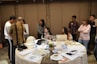 A diverse group of professionals collaborating around a table with laptops and documents.