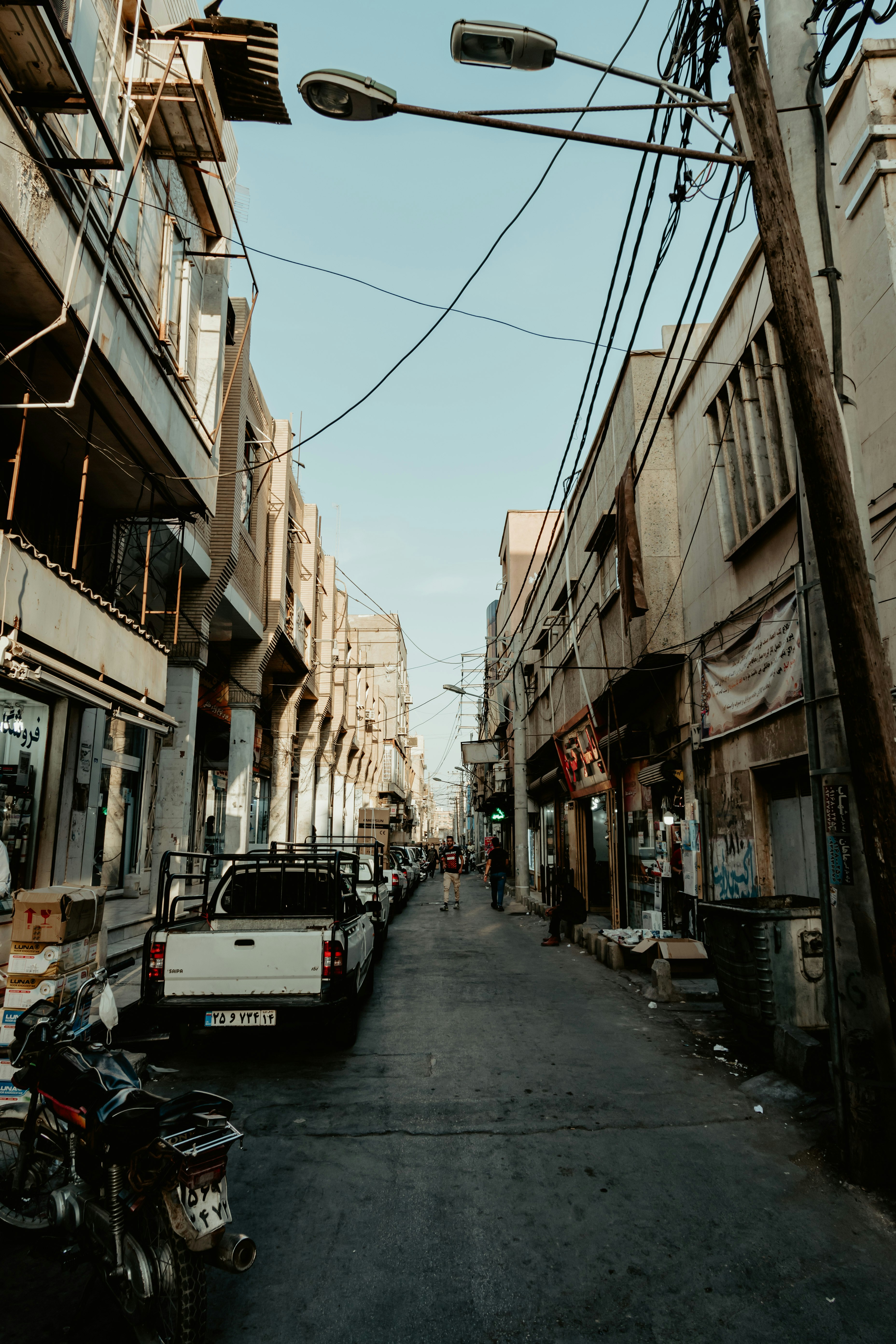 cars parked on street between buildings during daytime