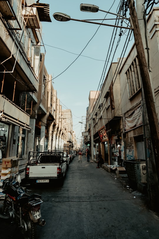 cars parked on street between buildings during daytime in Ahvaz Iran