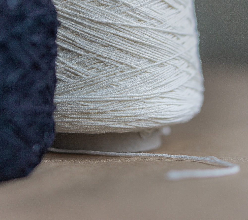 white thread on brown wooden table