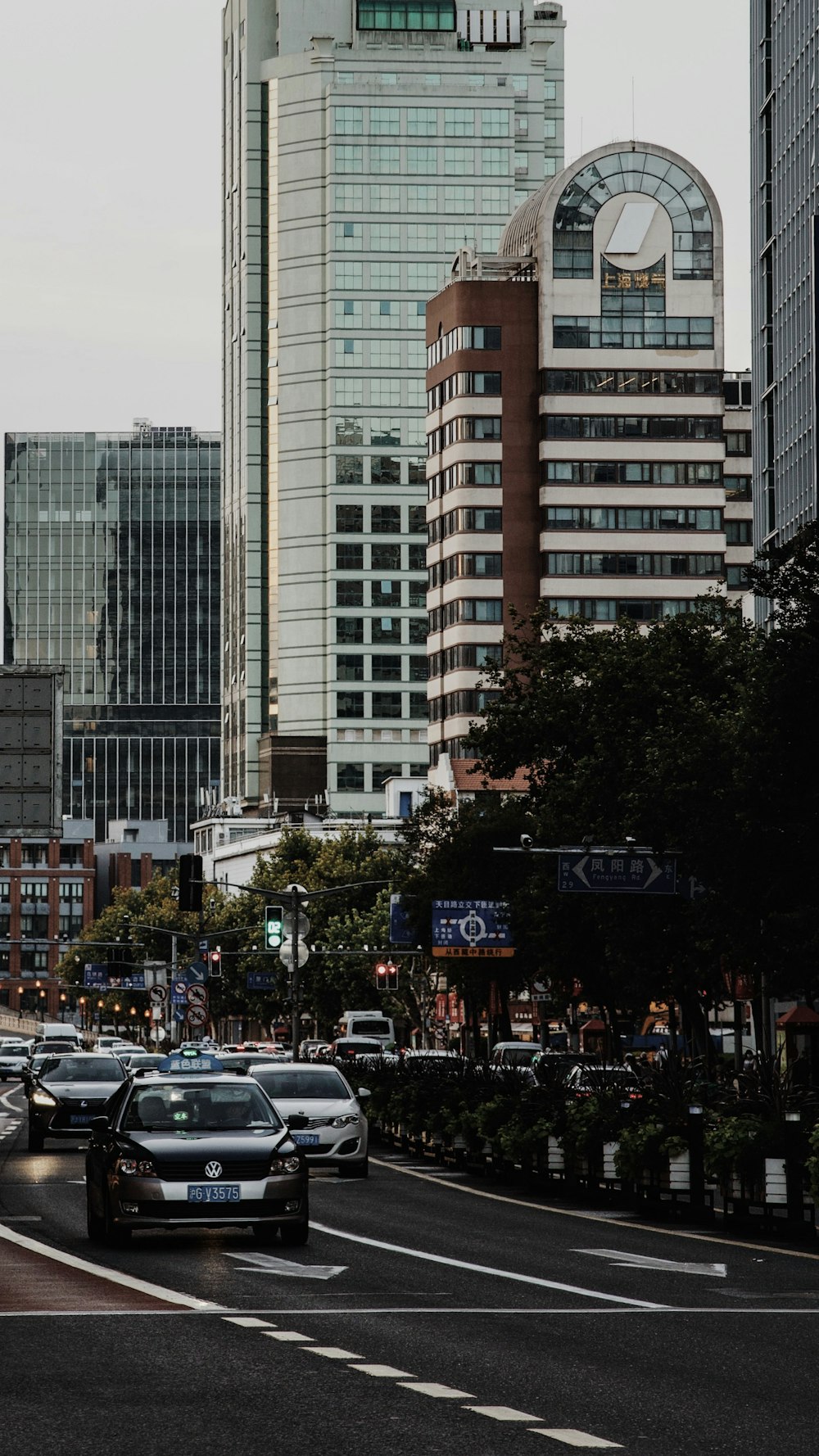 cars parked on parking lot near high rise building during daytime