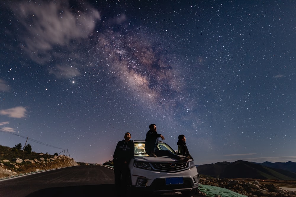 couple sitting on white and blue convertible car under starry night photo –  Free Blue Image on Unsplash
