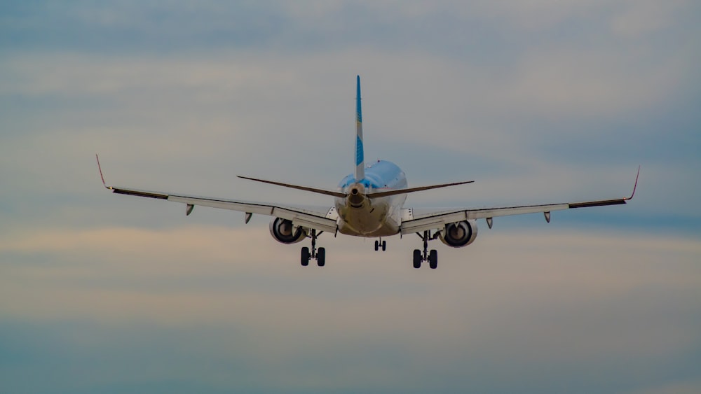 avião branco e azul no ar durante o dia