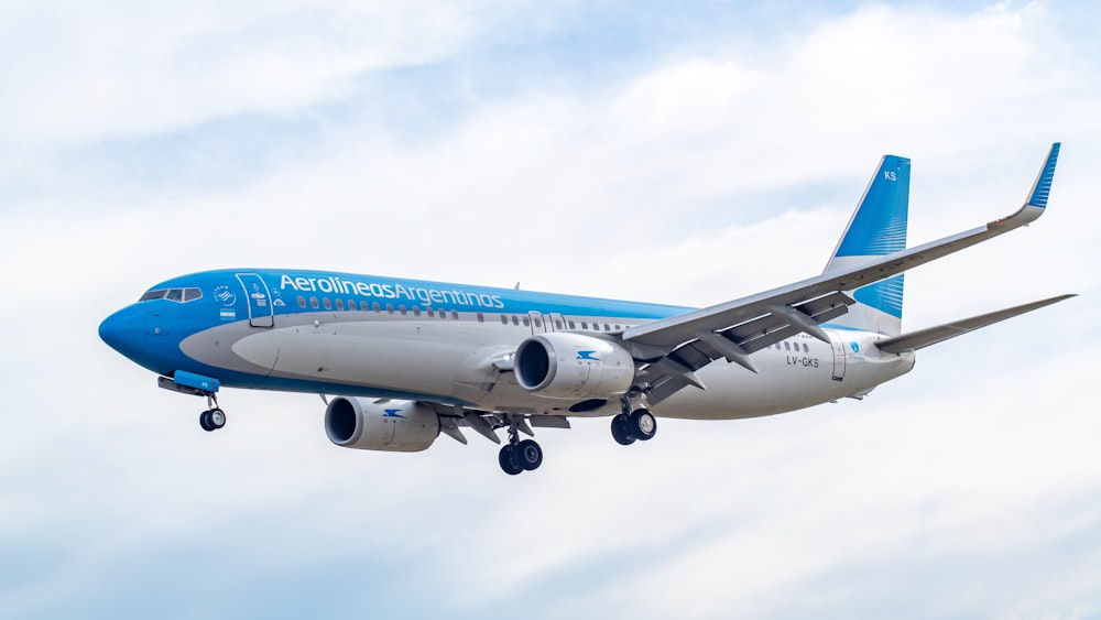 blue and white airplane flying during daytime