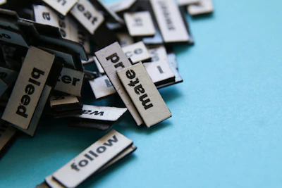 a pile of black and white typewriters sitting on top of a blue surface