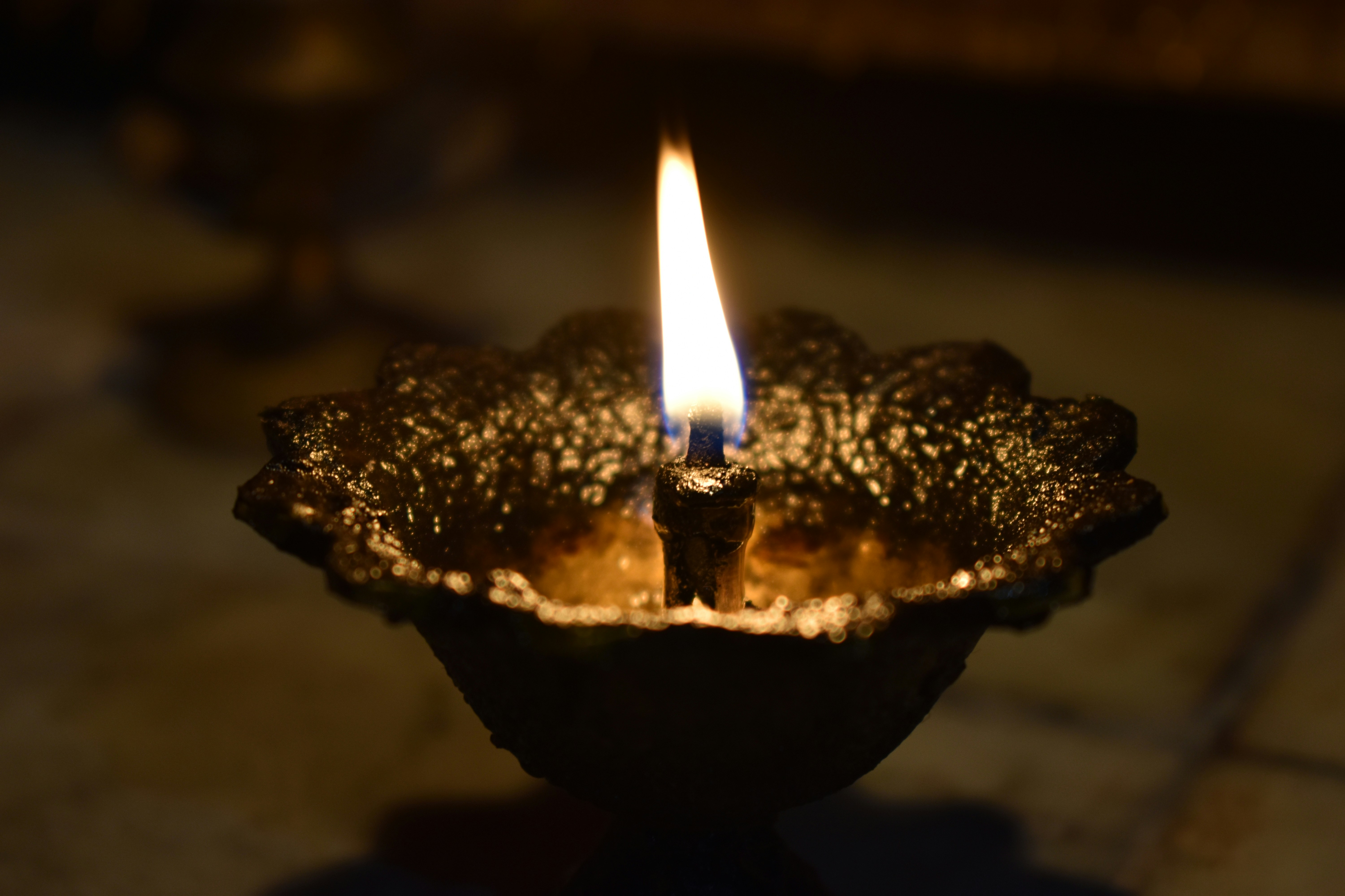 lighted candle in black ceramic bowl