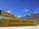 Two yellow directional signs indicate the directions to Kala Patthar and Everest Base Camp against a backdrop of snowy mountain peaks and a clear blue sky.