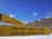 Two yellow directional signs indicate the directions to Kala Patthar and Everest Base Camp against a backdrop of snowy mountain peaks and a clear blue sky.