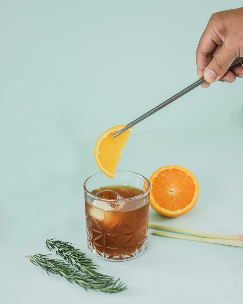 person holding clear drinking glass with orange juice