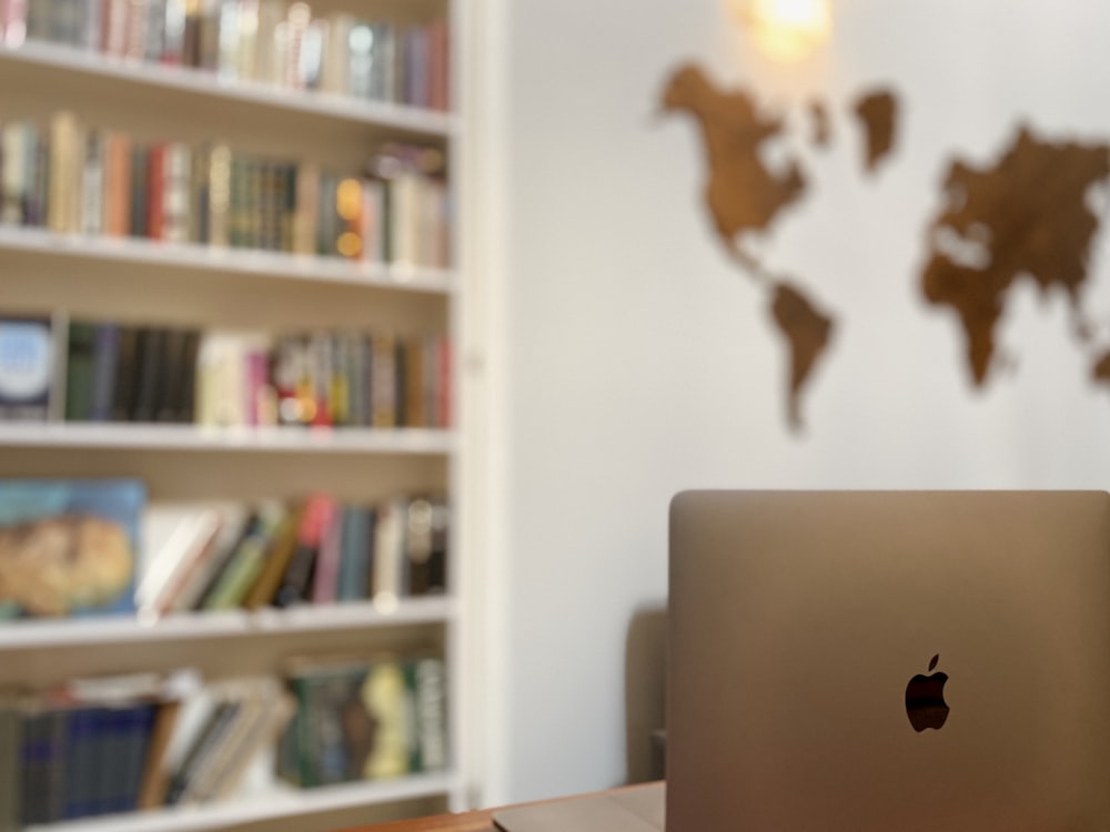 silver macbook on white table