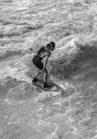Close-up of a surfer’s focused face as they prepare to catch a wave.