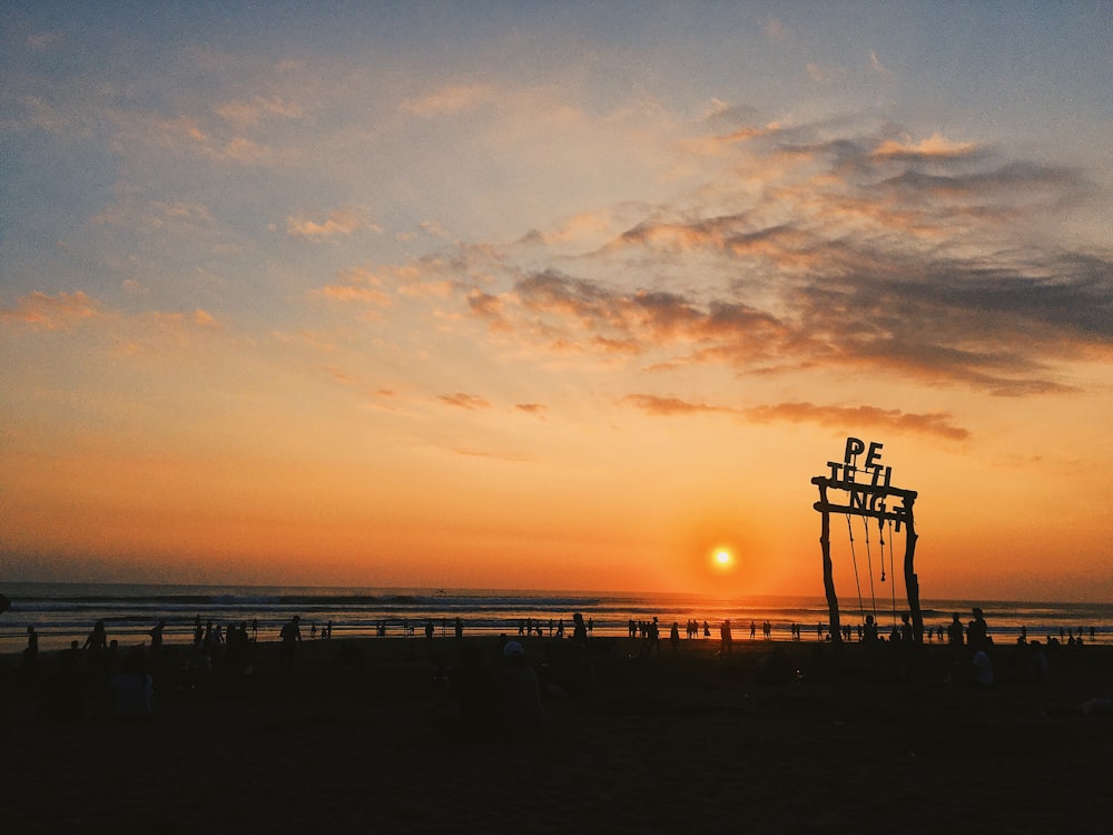 silhouette di persone sulla spiaggia durante il tramonto