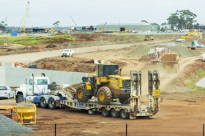yellow and black heavy equipment on brown field during daytime