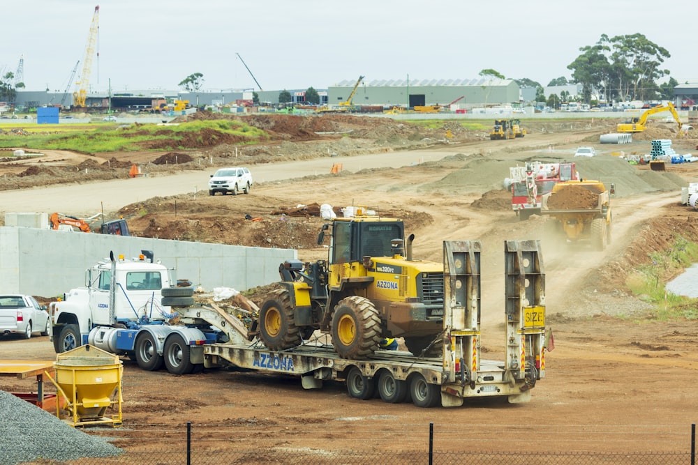 yellow and black heavy equipment on brown field during daytime