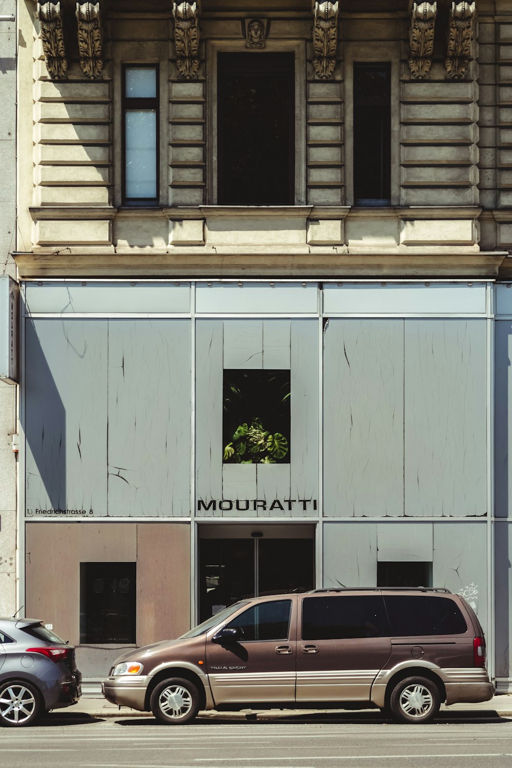 white car parked beside white building during daytime