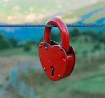 a red heart shaped padlock attached to a wire