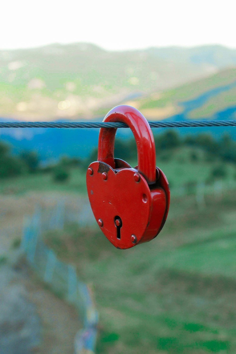 a red heart shaped padlock attached to a wire