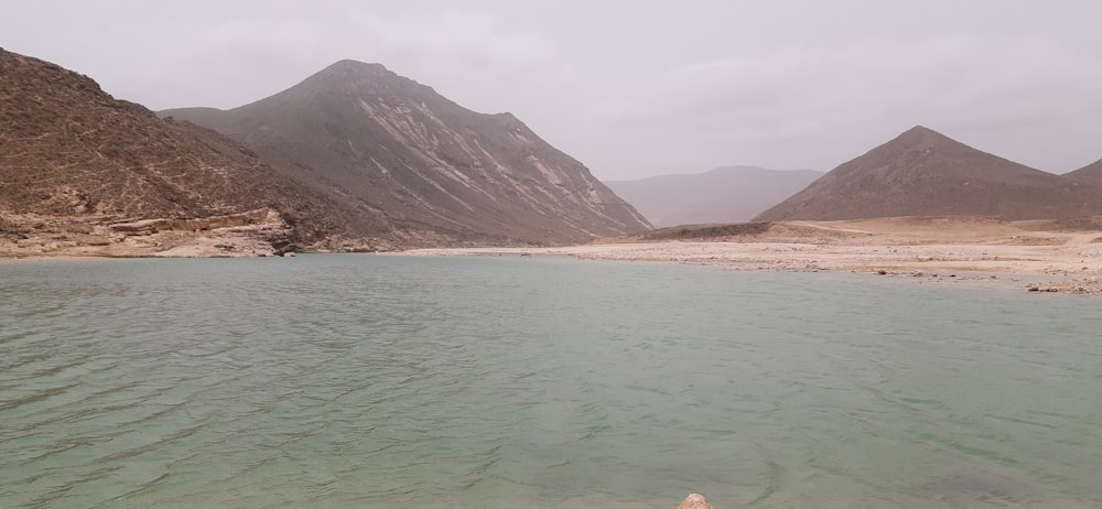 a body of water with mountains in the background