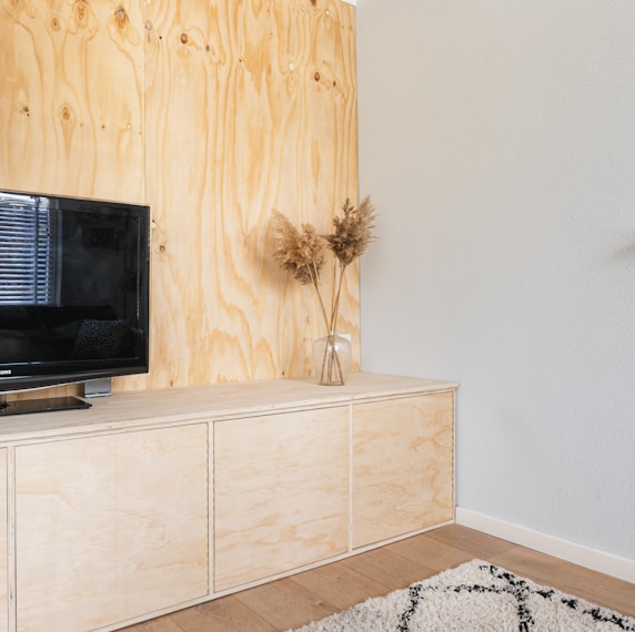 black flat screen tv on white wooden tv rack