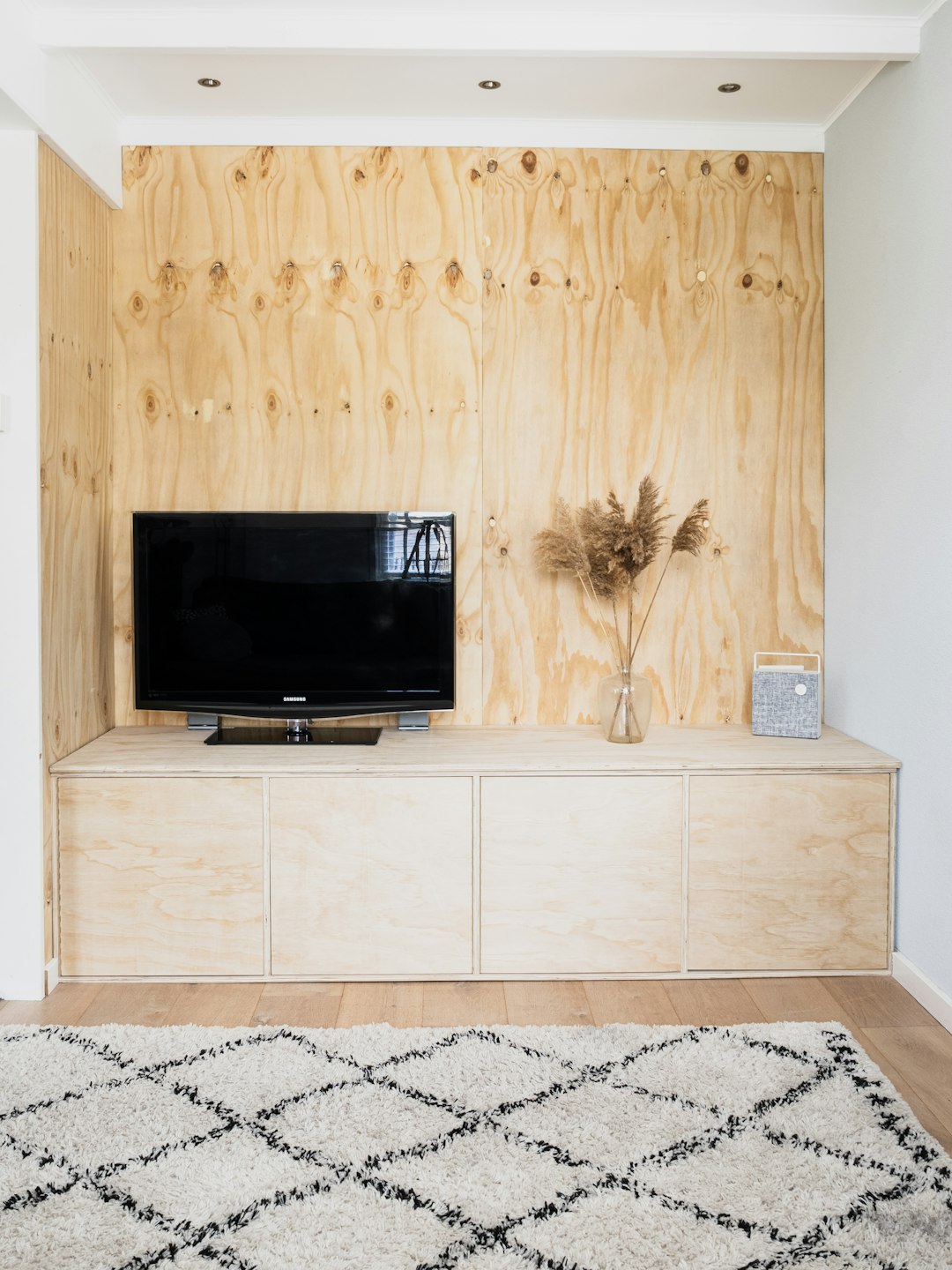  black flat screen tv on white wooden tv rack carpet