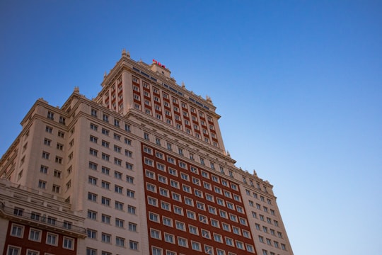 brown concrete building under blue sky during daytime in Edificio España Spain